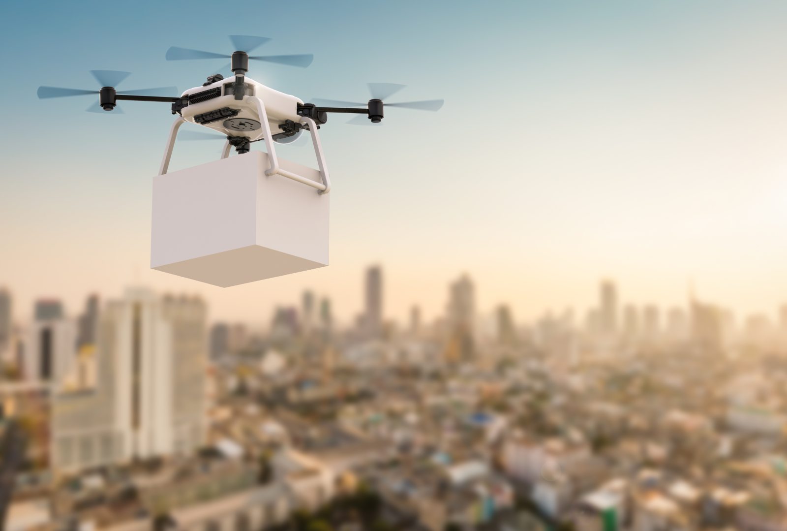 Drohne fliegt mit Paket über die Stadt
